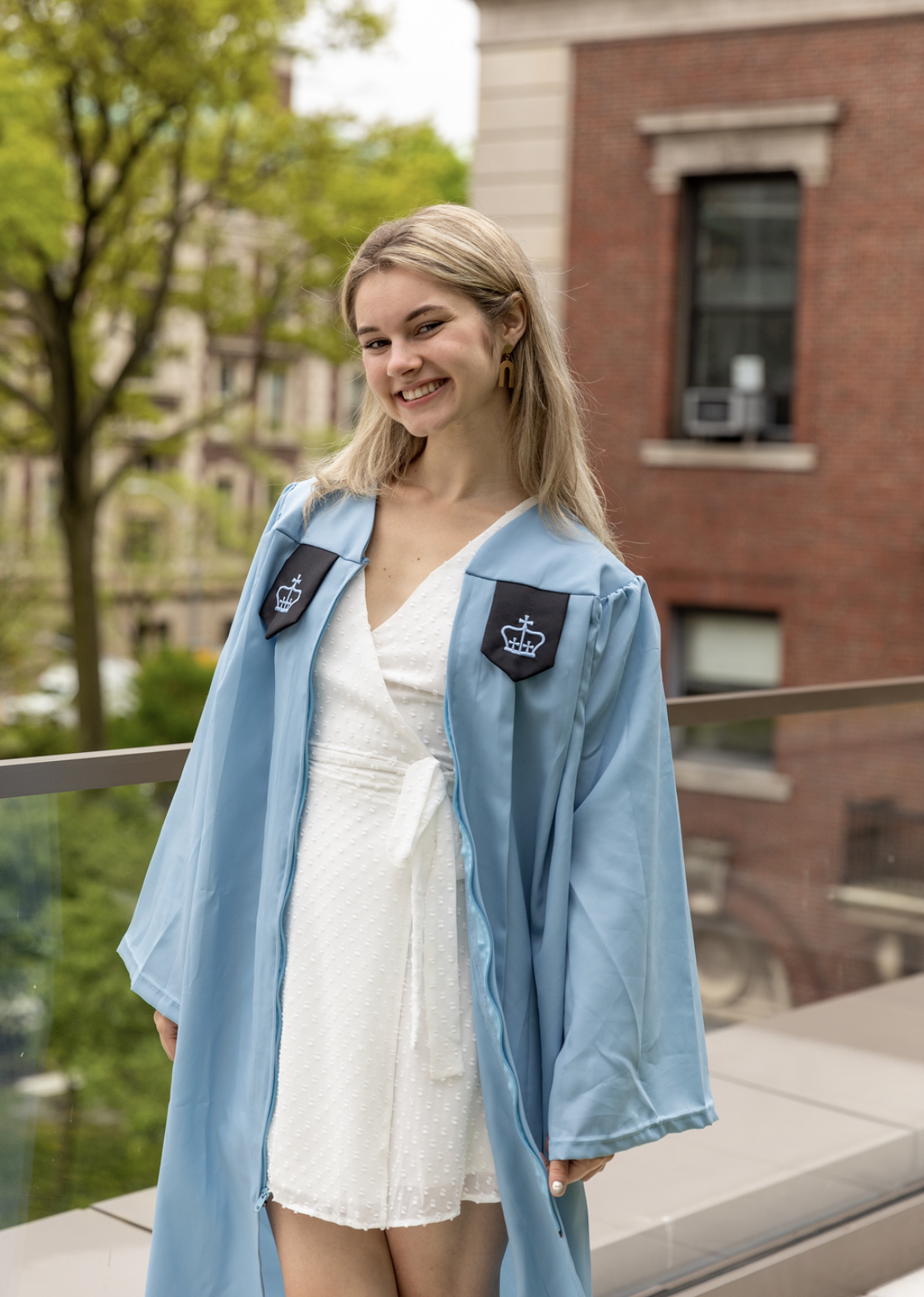 Audrey posing in her graduation gown on Barnard's campus